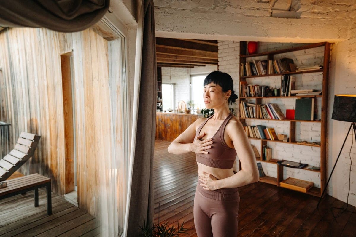 An adult standing in warm natural light at home, relaxed and healthy